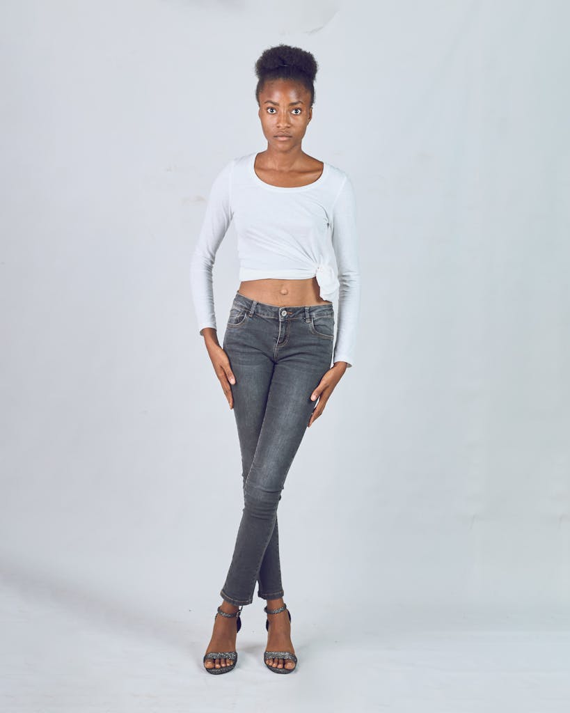 A woman in a white crop top and jeans