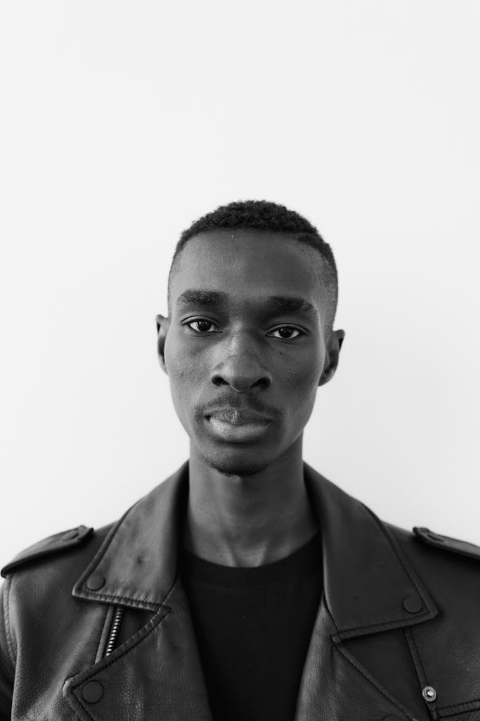 Grayscale Photo of a Man Wearing a Leather Jacket